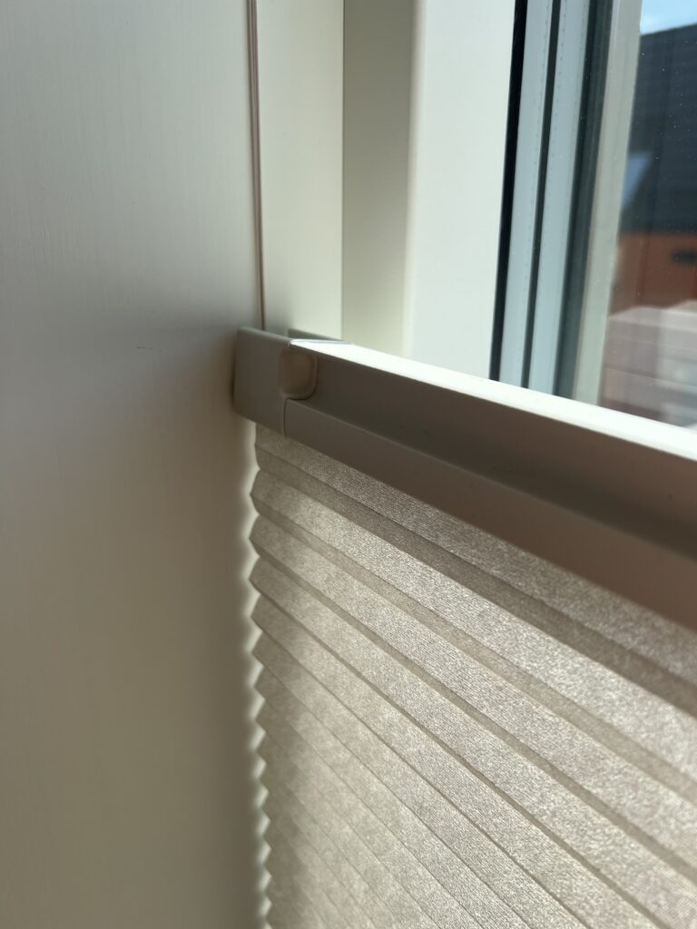 Nærbilde av plissegardin som viser struktur og lysdemping.