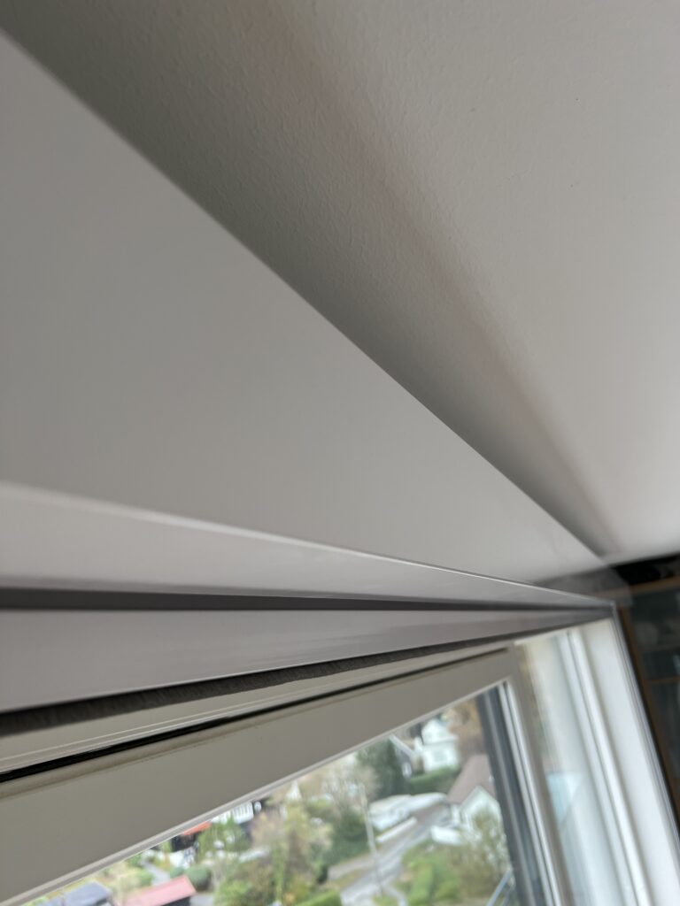 Detalj av innvendig solskjerming langs toppen av et vindu