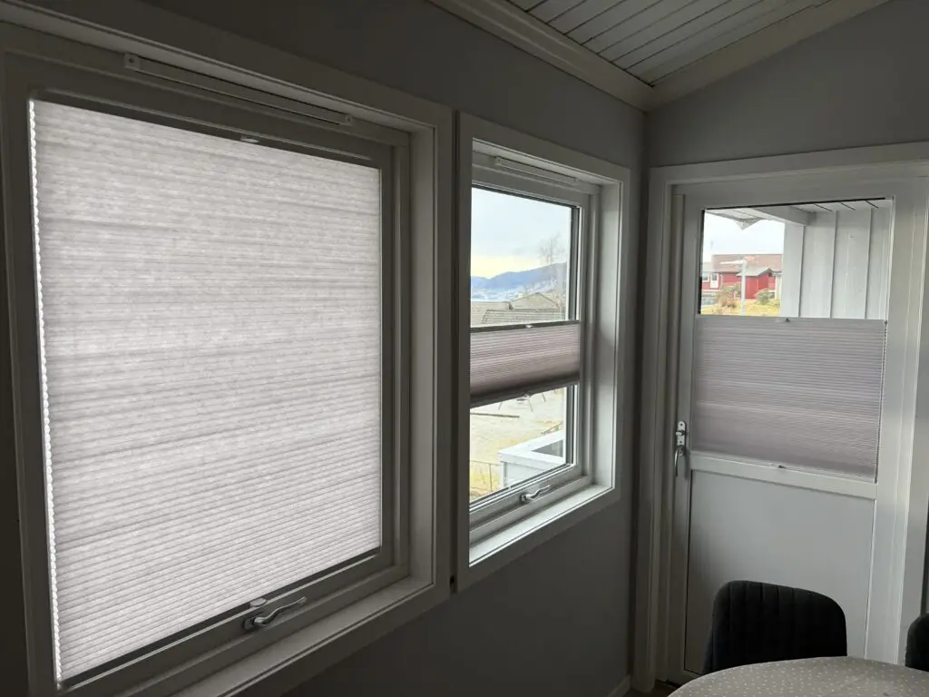 Separate plissegardiner montert på vinduer og terrassedør i samme rom