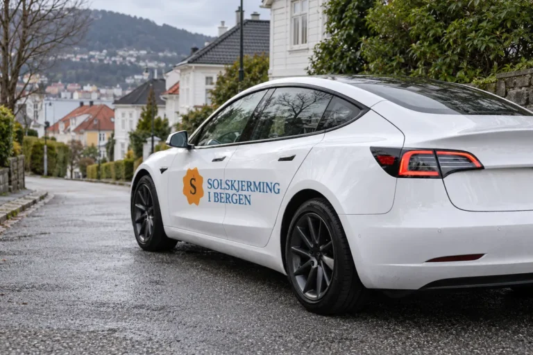 Hvit bil med Solskjerming i Bergen på døren i en boliggate